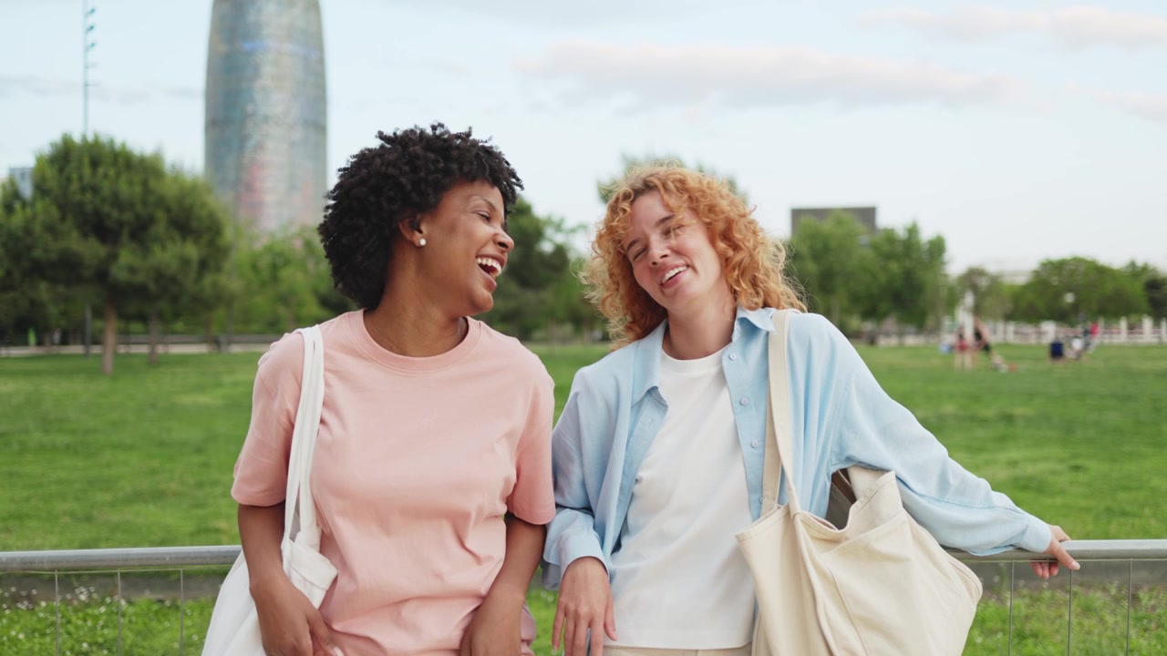 Two Happy Diverse Women Talking and Laughing in a City Park