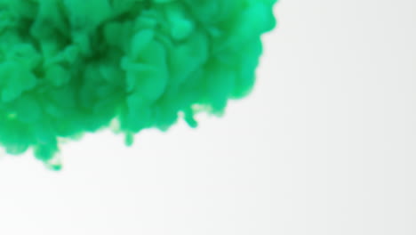 Green-Paint-Or-Dye-Dropped-Into-Water-Against-White-Background-To-Create-Swirling-Colourful-Smoke-Background