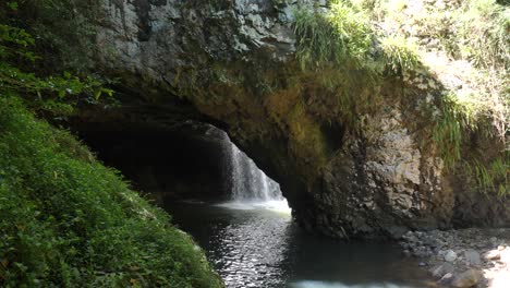 Unique-view-of-a-secret-swimming-hole-with-a-cascading-waterfall-set-in-a-moss-covered-rainforest