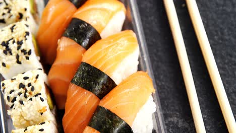 plastic tray of various sushi rolls with salmon