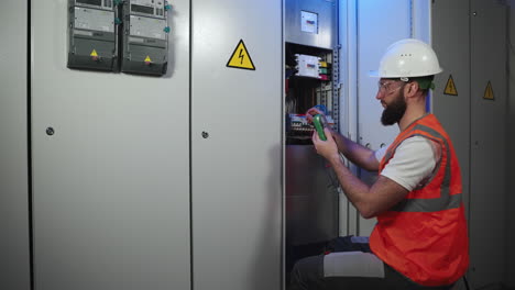 electricista que trabaja en el panel eléctrico