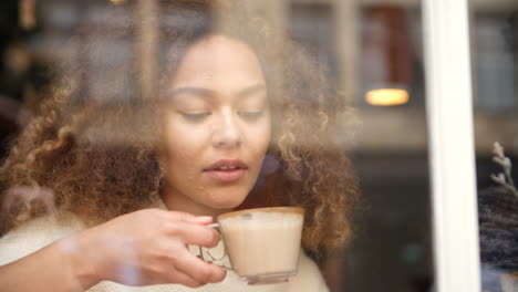 view through window of couple sitting in cafe