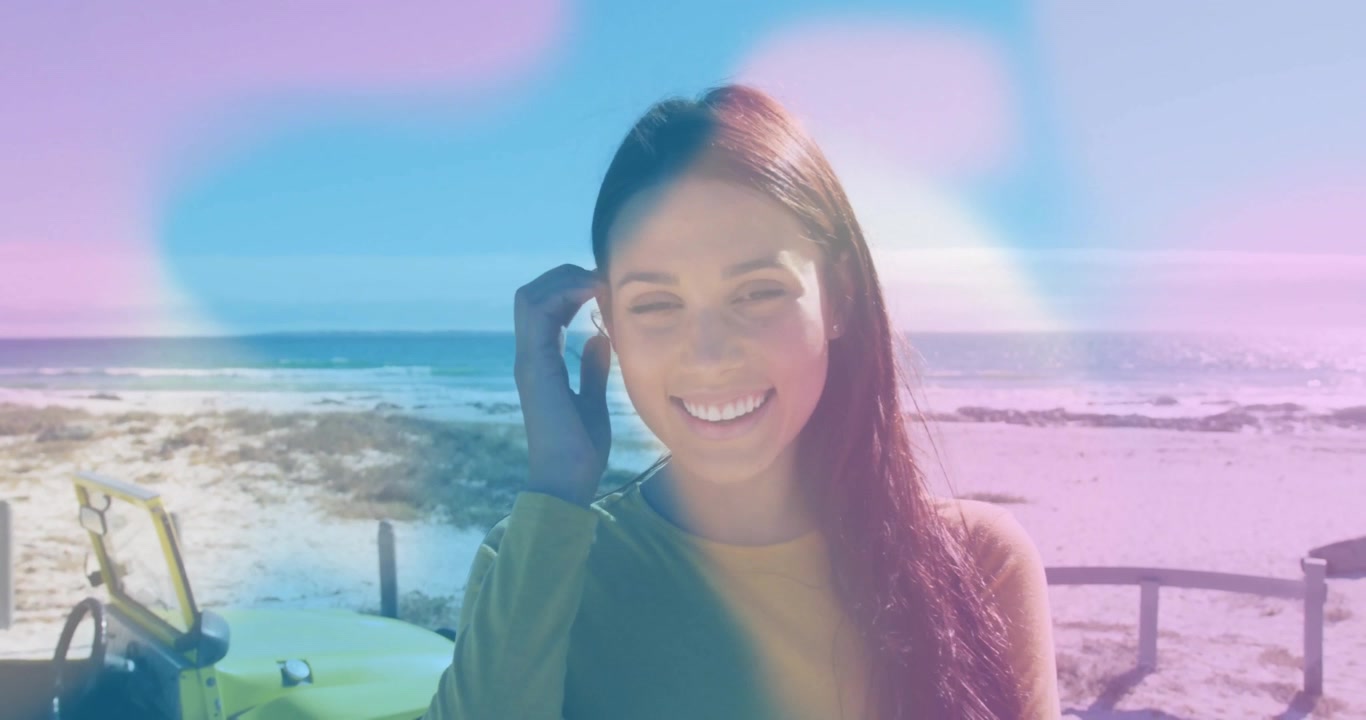 Donna che crea contenuti in spiaggia, avvia la registrazione mentre sistema l'auricolare, con un effetto lens flare pastello.