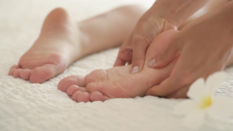 pretty young female feet receiving oil massage. close up of oil foot massage for young lady