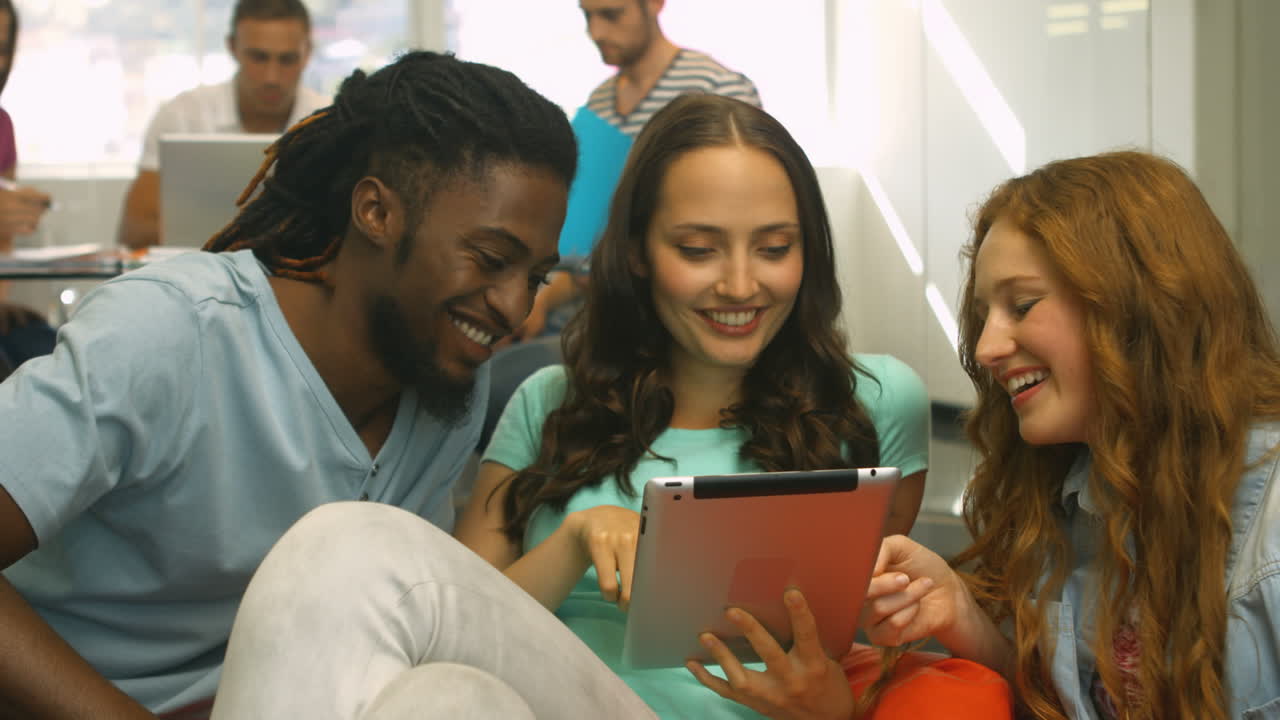 Students using tablet and smiling