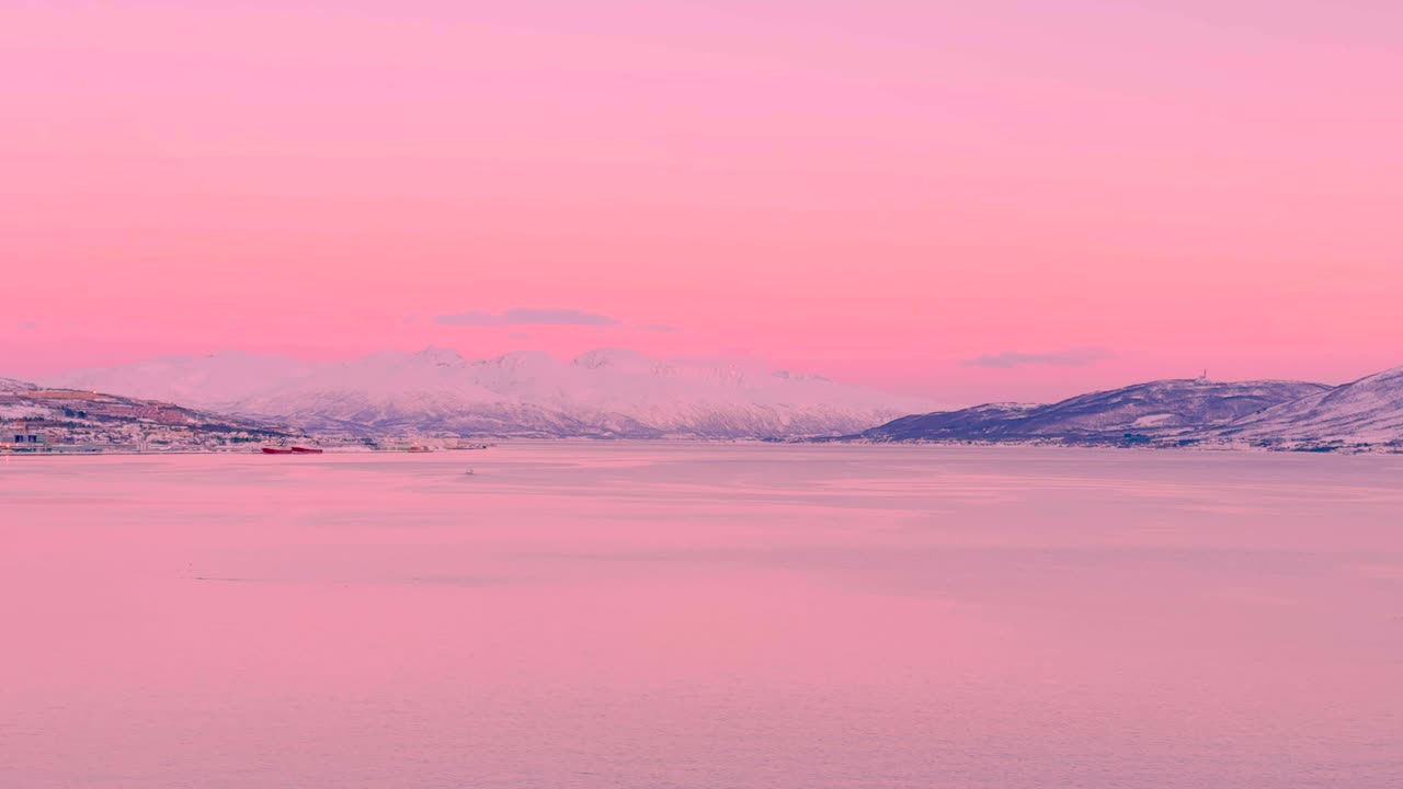 노르웨이의 트롬소에서 바다의 넓은 풍경, 분홍색 색조와 멀리 눈 인 산