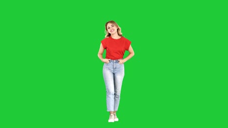 happy smiling woman with hand in pocket walking on a green screen, chroma key