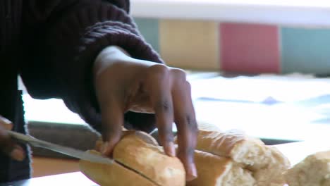 Nahaufnahme-Einer-Afroamerikanischen-Frau,-Die-Brot-Schneidet