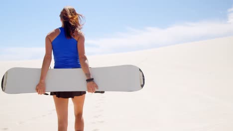 Woman-walking-with-sand-board-in-the-desert-4k
