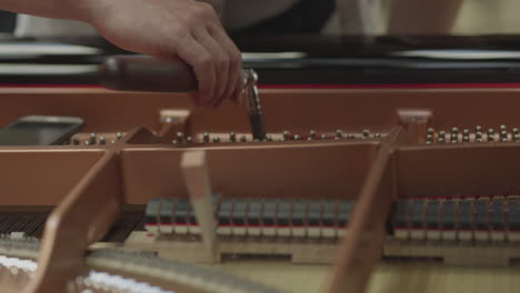 a person tuning a piano with specialty tools