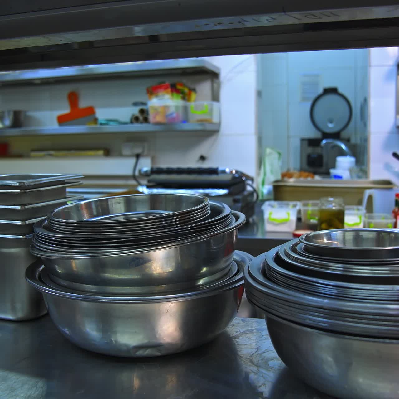 Stainless steel bowl for cooking. Kitchen utensils. Many bowls on shelf in kitchen