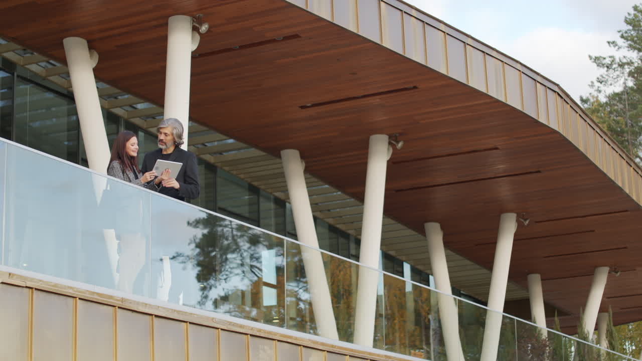 Business professionals discussing on a modern building balcony