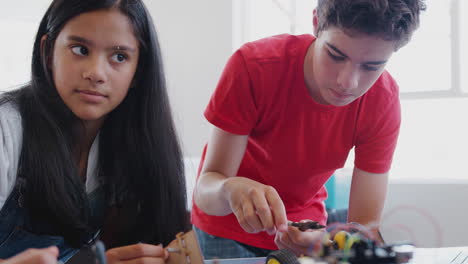 Two Students Building And Programing Robot Vehicle In After School Computer Coding Class