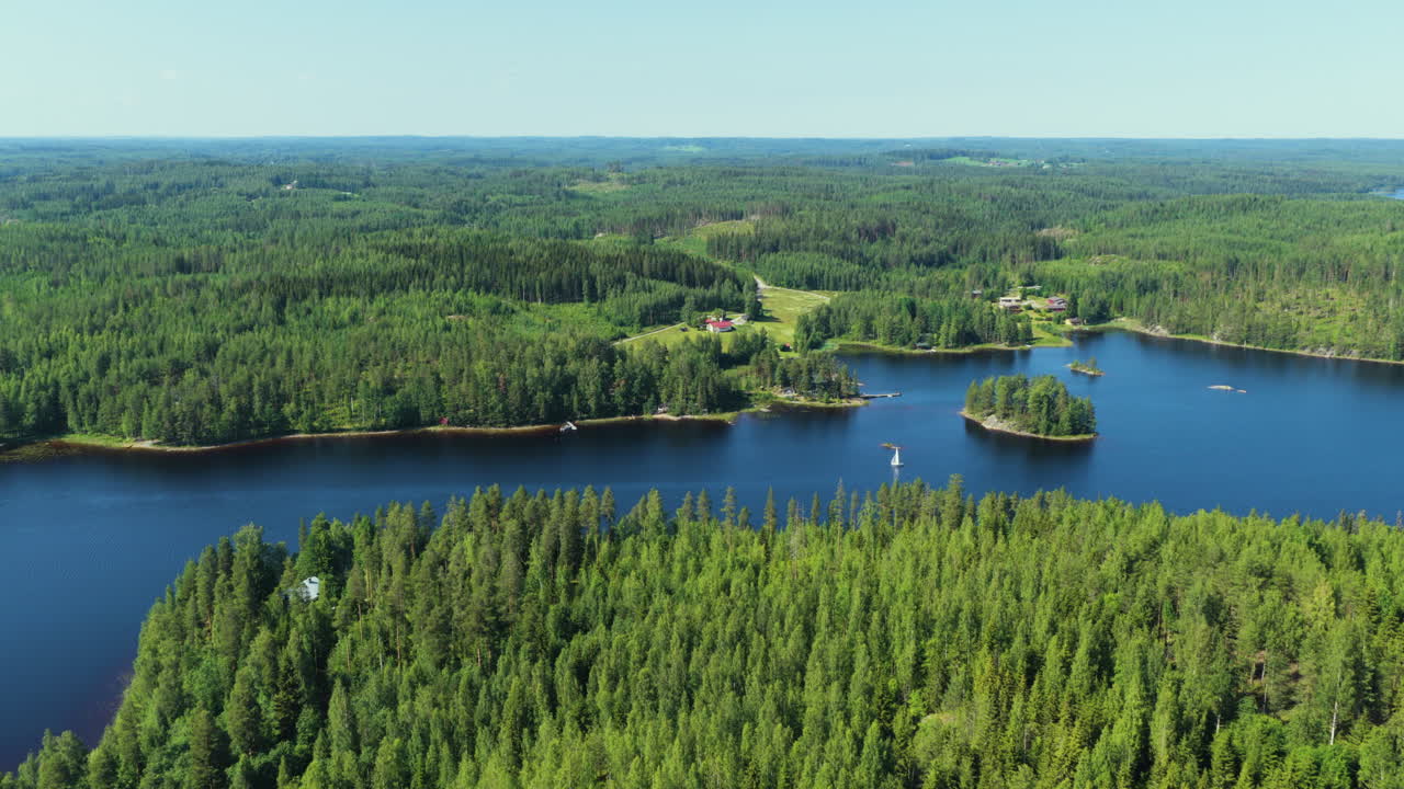 Drone approaching a sailboat sailing on lake Saimaa, summer day in Finland