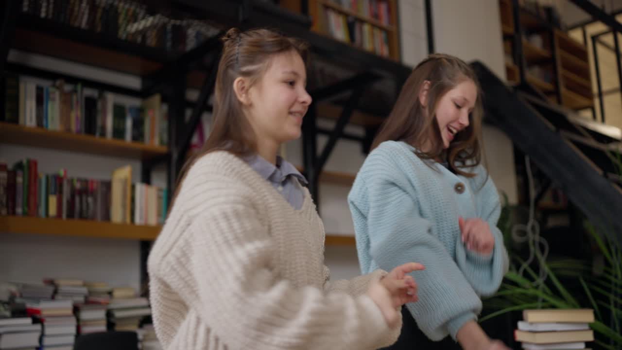 Two Teen Girls Dancing in a Library