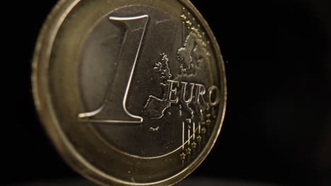 close-up of a 1 euro coin with a black background that is spinning