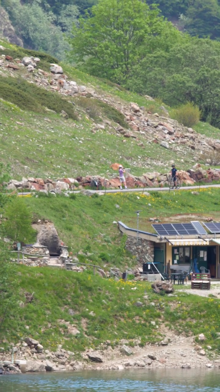 En liten fjellkafé med solcellepaneler har utsikt over en innsjø i Entracque, Italia