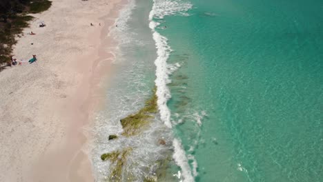 Luftaufnahme-über-Menschen-In-Den-Wellen,-Am-Hyams-Beach-In-Jervis-Bay,-NSW,-Australien---Neigung,-Drohnenaufnahme