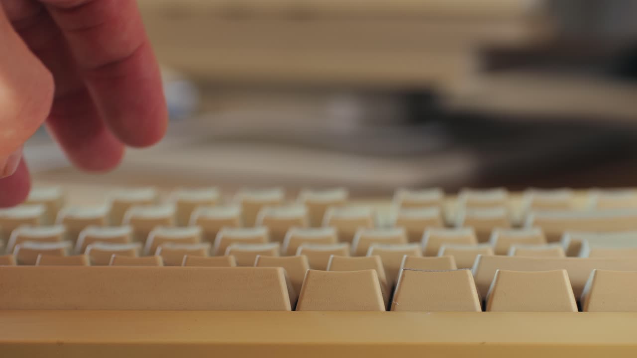 Man working and gaming on retro computer PC, IT engineer with vintage computer at home, using old fashion technology, close up of retro setup.