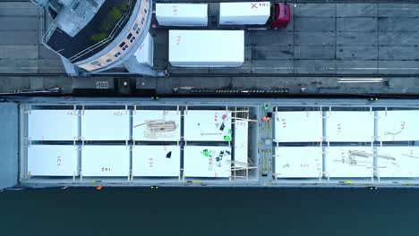 descending top down shot worker on container ship in harbor