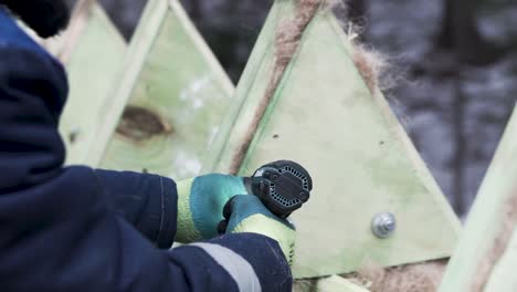 construction worker using drill on wooden structure