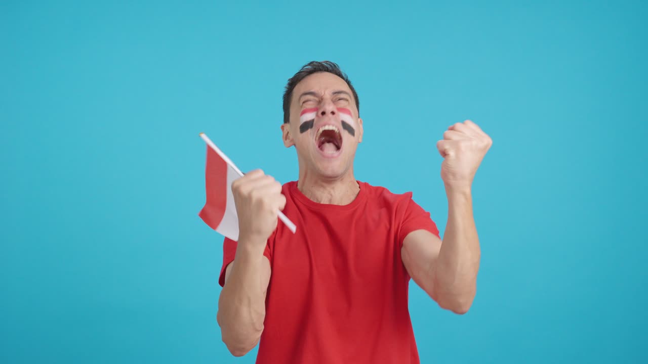 Man cheering for Egypt screaming and waving a national flag