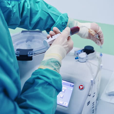 stem cell research. laboratory worker holding syringe with blood near the modern equipment. contemporary apparatus in clinic.