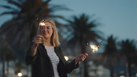 Mujer-Joven-Bailando-Con-Bengalas-En-La-Playa-Al-Atardecer-Celebrando-La-Víspera-De-Año-Nuevo-Divirtiéndose-Celebración-Del-Día-De-La-Independencia-Con-Fuegos-Artificiales-Disfrutando-De-La-Libertad