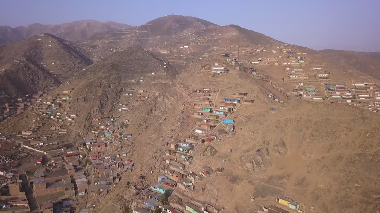 An expansive hillside settlement with colorful homes scattered across a dry, rugged landscape. Ideal for editorial, urban development, and social documentary projects.