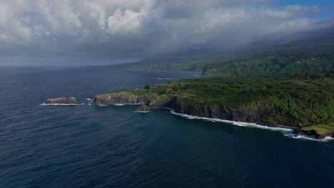 Flying-over-rocky-cliff-and-pacific-ocean-off-north-coast-of-Maui,-Hawaii