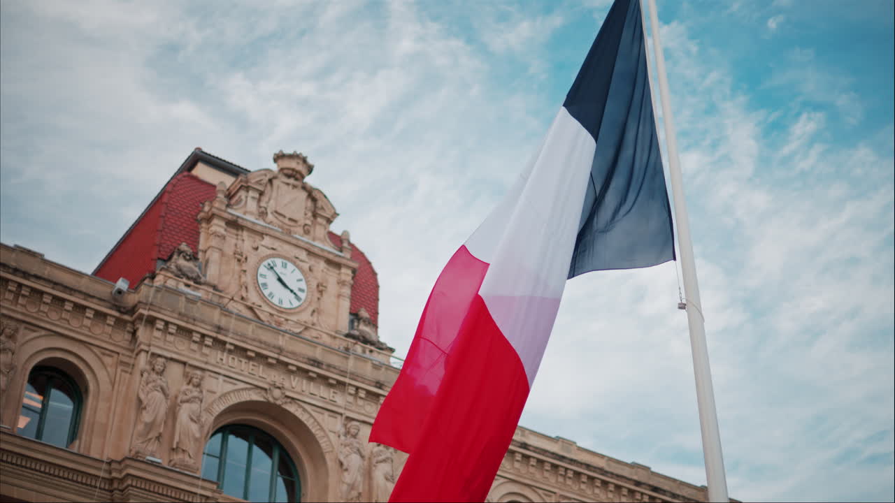 French flag waving in front of the Mairie de Cannes Town hall in Cannes, France