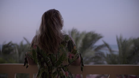 Mujer-Joven-En-Un-Balcón-Mirando-A-Lo-Lejos-Y-Disfrutando-Del-Viento-Por-La-Tarde