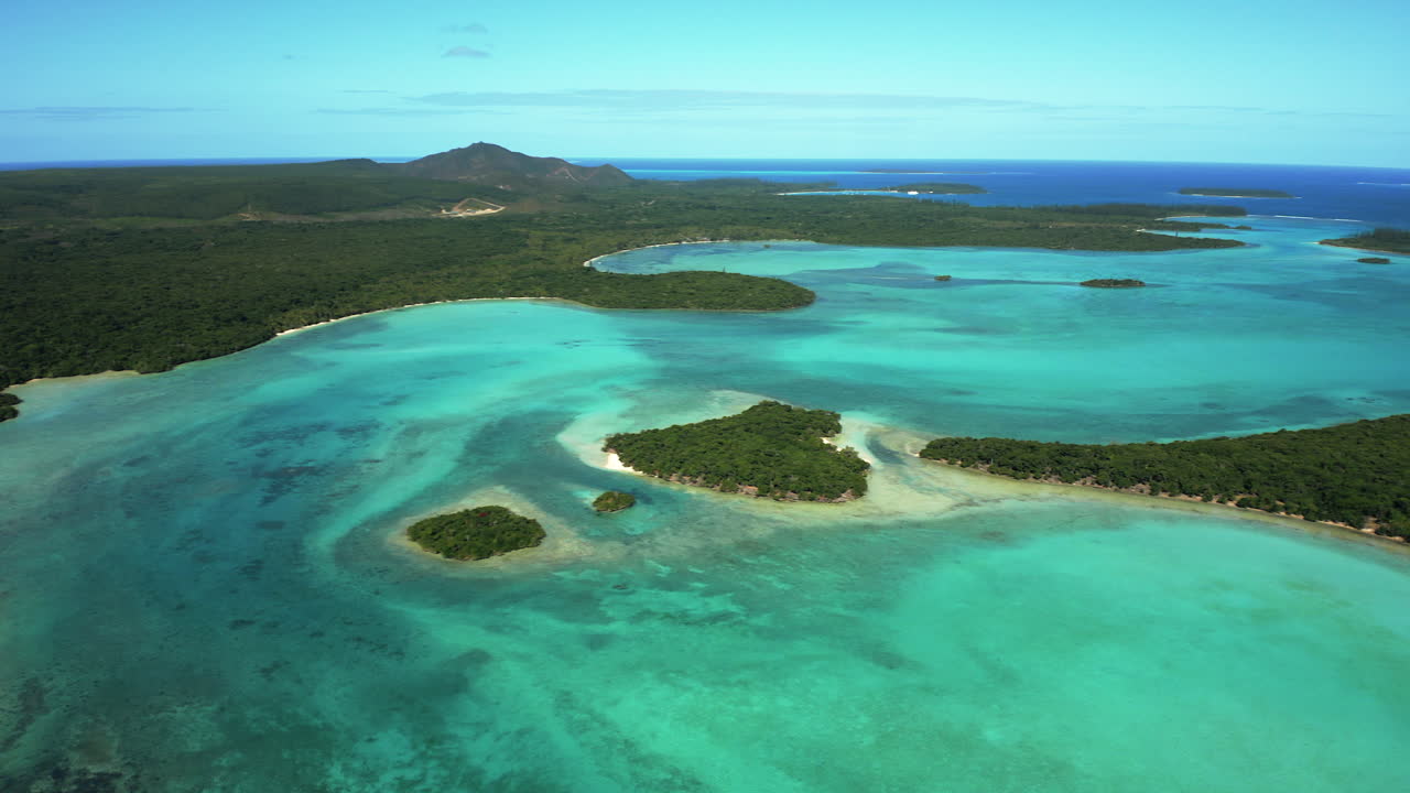 Wide establishing view of Pic N’ga, calm bay, scenic deserted islands off Isle of Pines