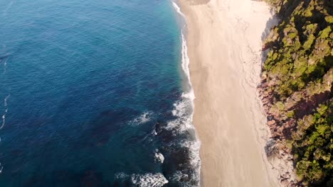 Seguimiento-De-Drones-Hacia-Adelante-Sobre-La-Popular-Playa-De-Monro,-Lugar-Escénico-En-La-Costa-Oeste-De-Nueva-Zelanda---Antena