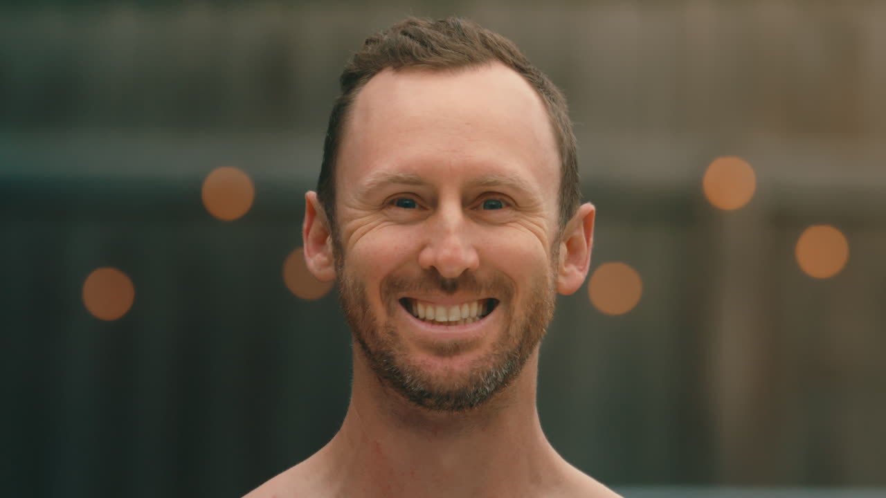 hombre golpeado por 2 globos de agua rosados en la cara sin romperse, de cerca en extrema 4k 800fps cámara lenta