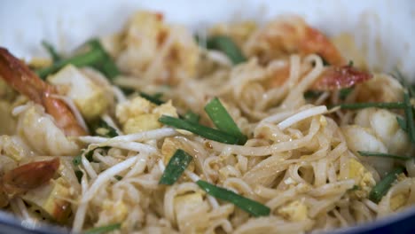 Female-Hand-Squeezing-a-Piece-of-Fresh-Green-Lime-on-Shrimp-Pad-Thai