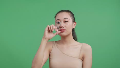 Woman using eyelash curler