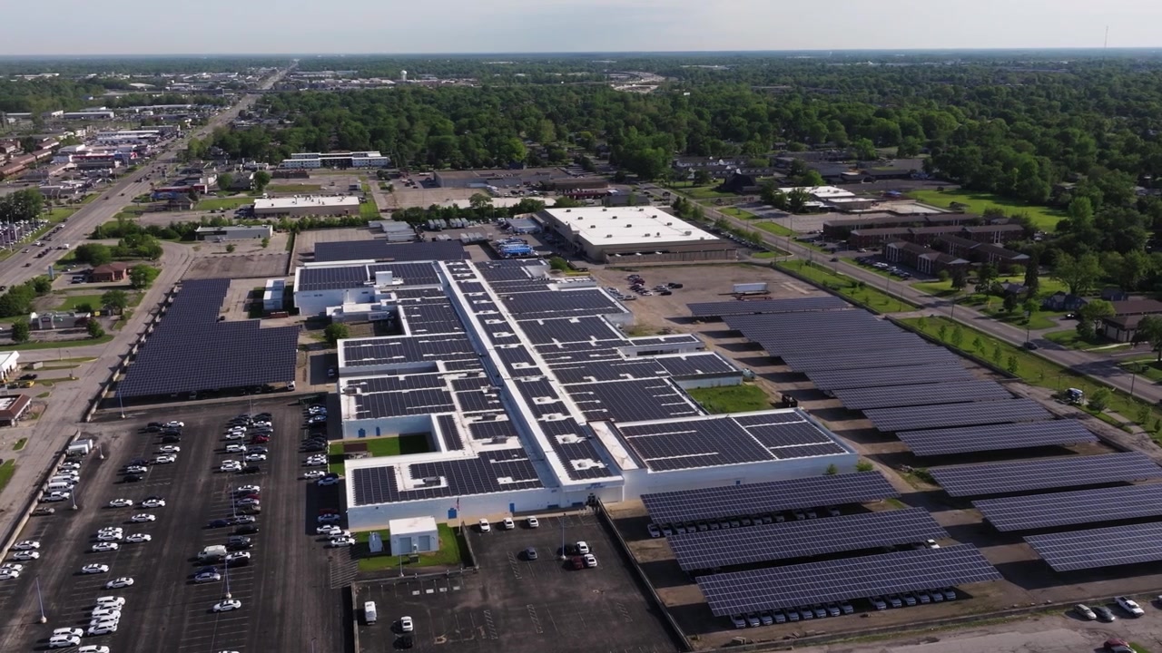 Bredt luftbårent panoramisk etableringsskud af et solcelledrevet datacenteranlæg, drone i kredsløb.