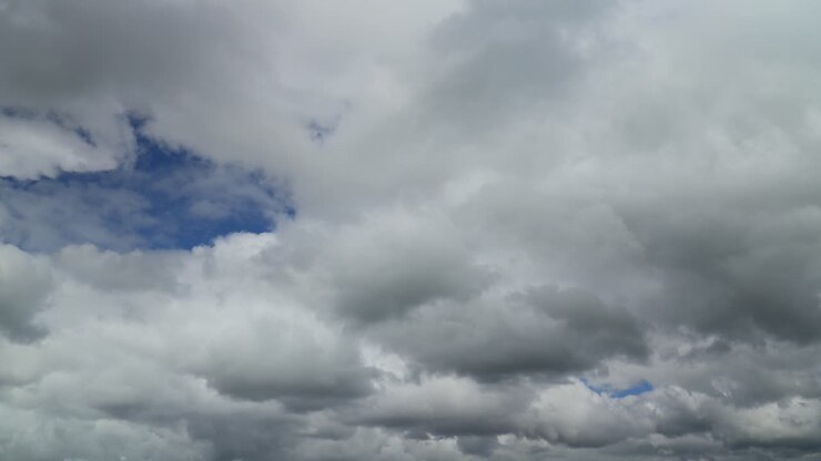 White and grey thick cloud developing and moving towards horizon on windy spring day