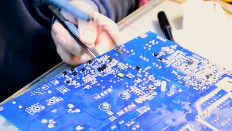 repairing a circuit board with soldering iron