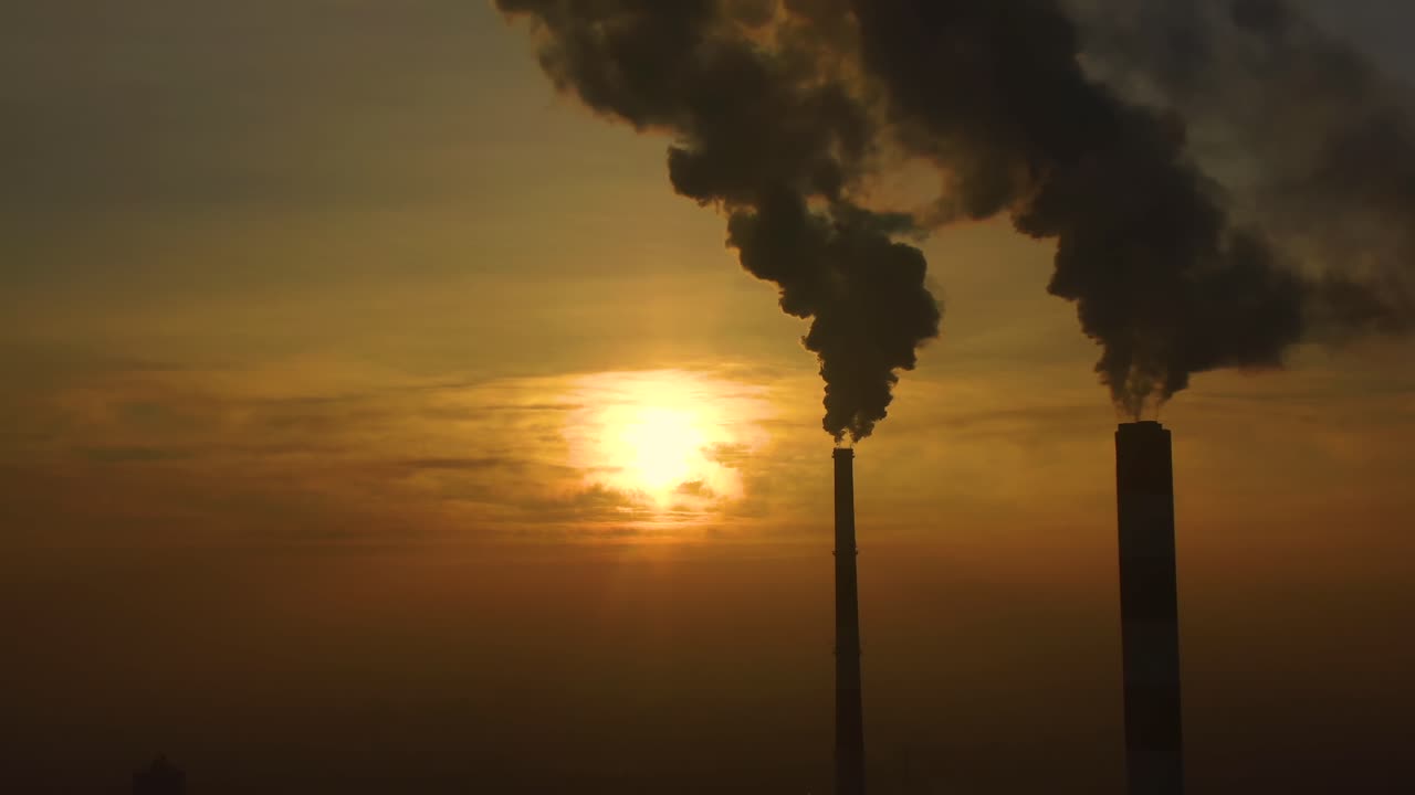 emisiones de la planta de energía vistas sobre la ciudad durante el amanecer