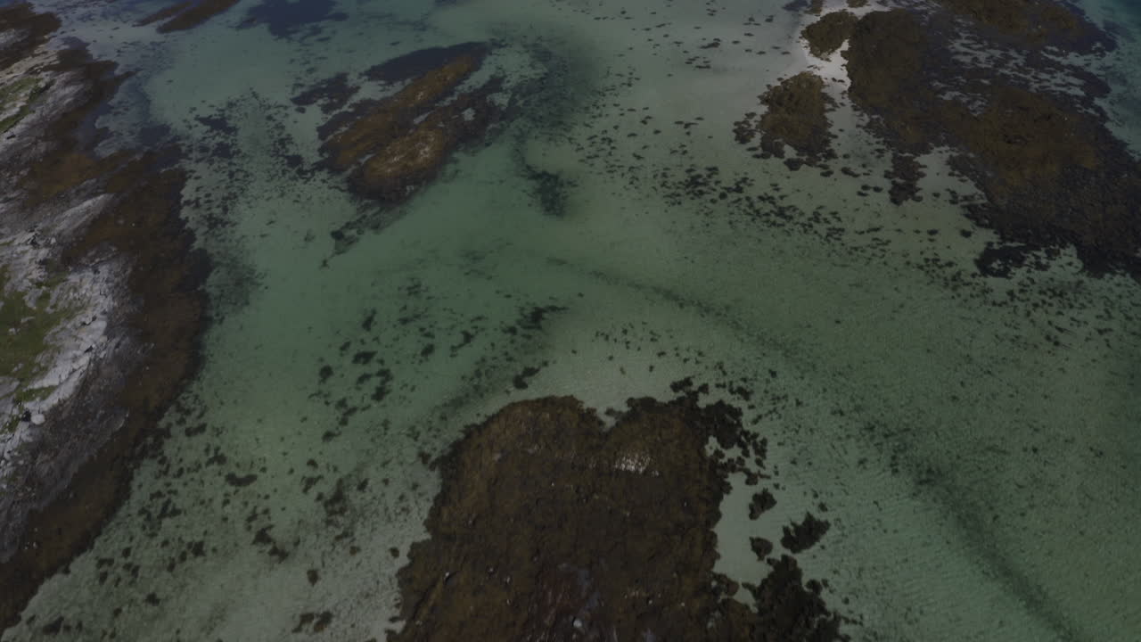 An aerial drone shot panning up to reveal Torghatten mountain, a mountain on Norway’s Helgeland coast with a hole right through the middle. Brønnøysund, Norway