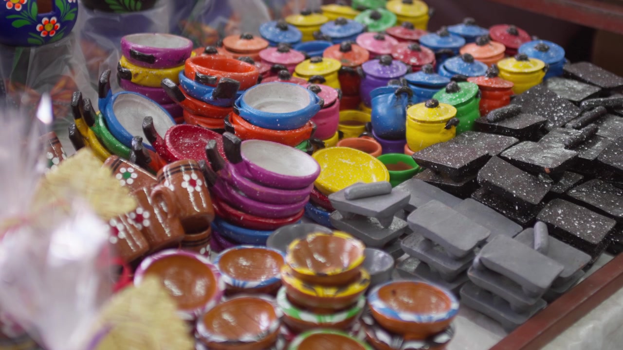 Cuencos de cerámica coloridos y artículos de alfarería dispuestos en un puesto de mercado artesanal, exhibición de artesanías hechas a mano.