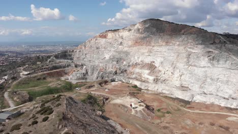 Órbita-Aérea-Enormes-Camiones-De-Cantera-Descargan-Suelo-Grava-Restauración-Fondo-De-La-Ciudad