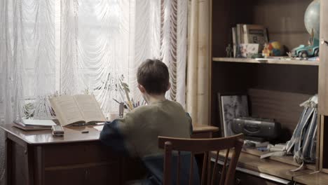 boy studying at a wooden desk