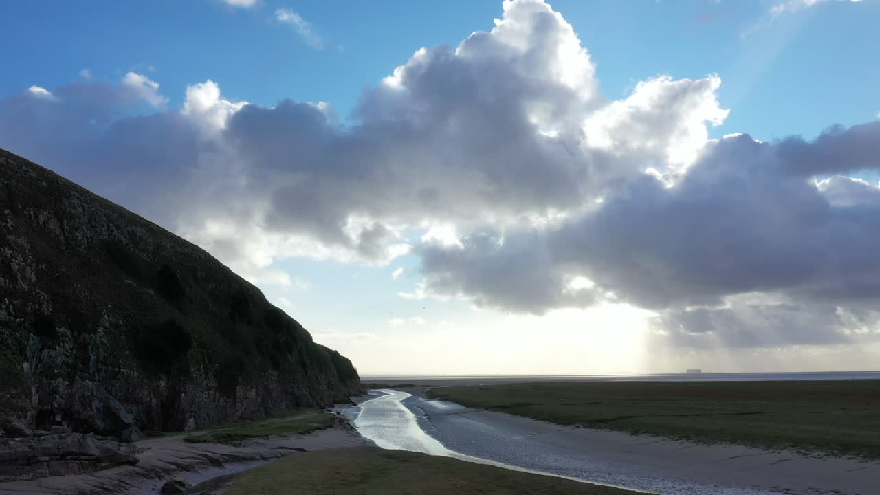 воздушная обувь приливных ручьев и холмов в английском районе озер, показывая солнце за большими облаками и голубым небом