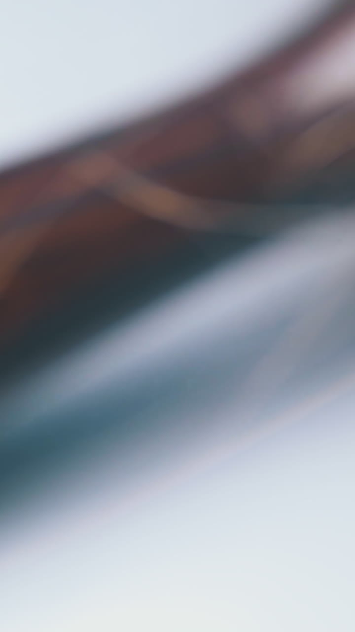 motion along ellipse hairbrush covered with hair locks and blurred handle on grey surface extreme close view