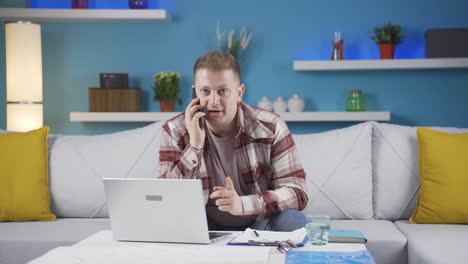 Home-office-worker-man-talking-on-the-phone-happily.