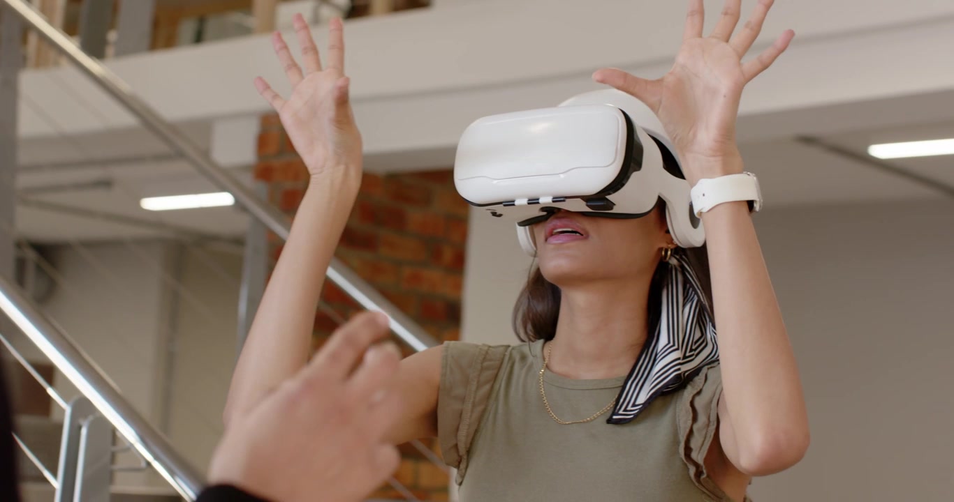 Mulher ajustando headset de VR após orientação do assistente, depois alcançando, apontando e tocando em demonstração em loft