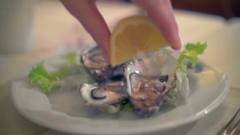 pouring lemon juice on oysters